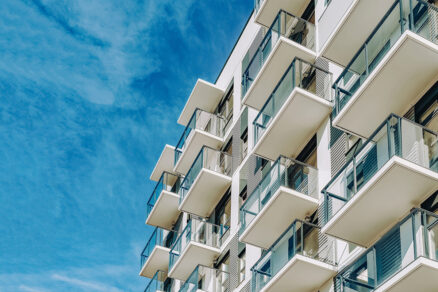 Moderný bytový dom s presklenými balkónmi a minimalistickou fasádou