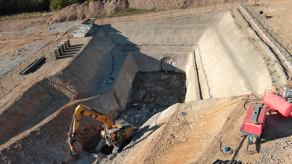 Obr. 3 Realizace sjízdné rampy portálové jámy s již dokončeným IBO deštníkem průzkumné štoly a odbouraným betonem v místě zarážky štoly