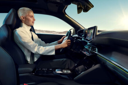 Řidička za volantem moderního interiéru vozu Peugeot s dotykovým displejem