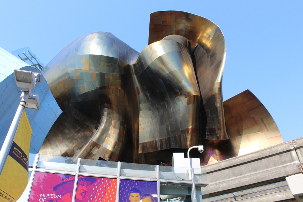Museum of Pop Culture (MoPOP), Seattle (2000) - Excentrická budova s futuristickými tvary a lesklým obkladem působí jako hmotná reprezentace hudby a popkultury. Muzeum původně vzniklo jako Experience Music Project a odráží Gehryho fascinaci hmotou, barvami a emocí v architektuře.