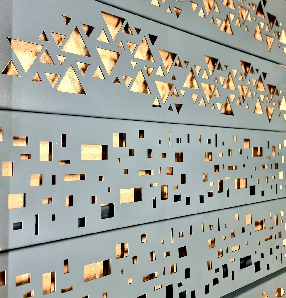 Fasádní obklad z perforovaného plechu s geometrickým vzorem a podsvícením.