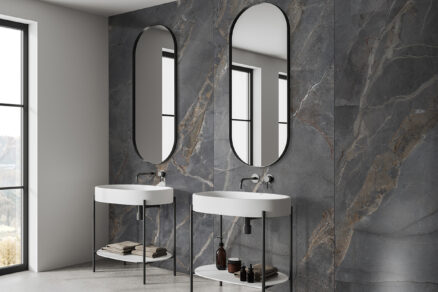 Elegantní koupelna s tmavými designovými panely na stěnu a oválnými zrcadly