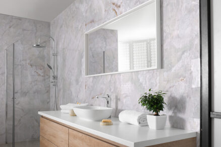 Koupelna s mramorovými designovými panely na stěnu a minimalistickým vybavením