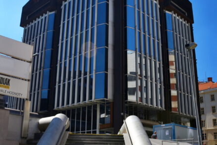 Zábradlí u jedné z budov, odkazující svými tvary na plynárenské potrubí