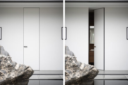 Minimalistické interiérové dveře ve skryté zárubni bez obložek, v jedné rovině se stěnou, v moderním interiéru