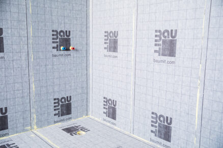 Hydroizolační membrána instalovaná na stěnách a podlaze koupelny před pokládkou keramických obkladů