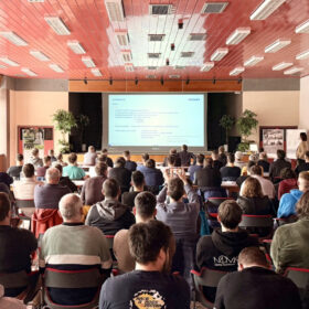 Odborný workshop o průmyslových podlahách ve školícím centru s plným sálem účastníků během odborné prezentace o návrhu a realizaci betonových podlah.