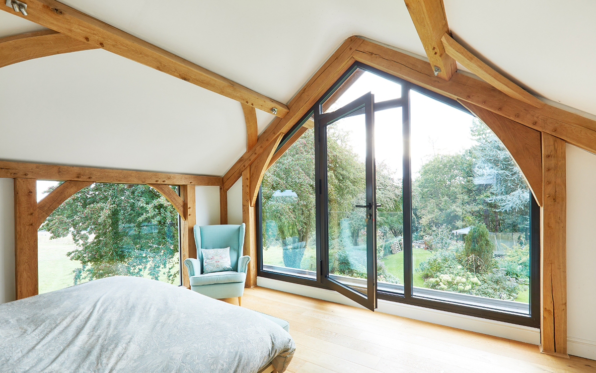 Ložnice s dřevěnými trámy a panoramatickým oknem