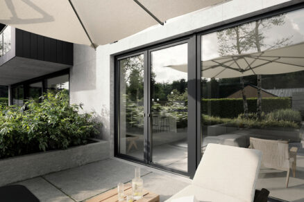 Terasa rodinného domu s velkými posuvnými dveřmi v kompozitním okenním systému