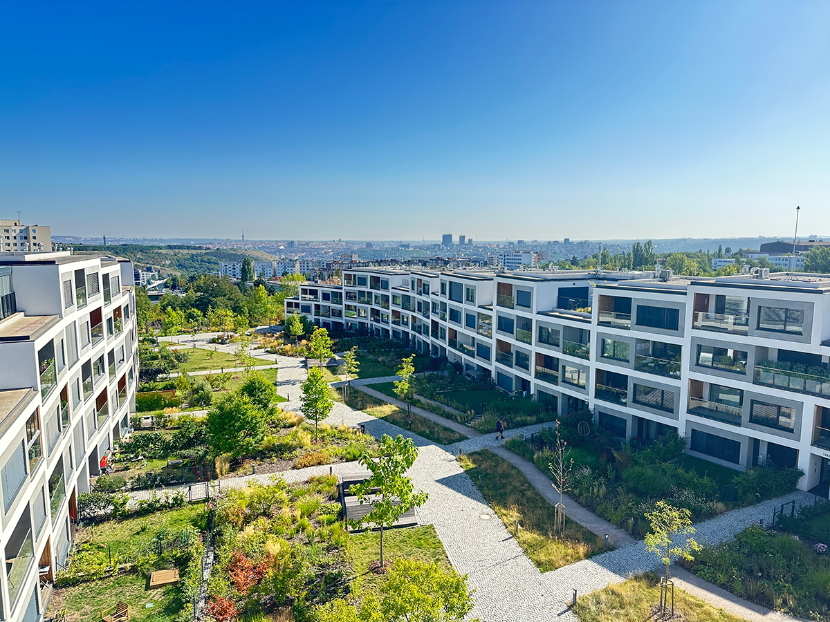 Současný bytový komplex s vnitroblokem a zelení v městské zástavbě