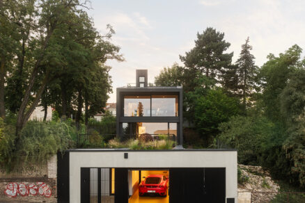 Pohled na rodinný dům Black House v Praze s terasou, zelení a integrovanou garáží