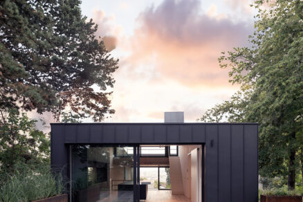 Prosklený obytný prostor rodinného domu s výhledem do zahrady a moderní architekturou