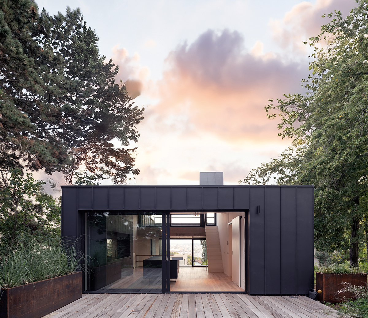 Prosklený obytný prostor rodinného domu s výhledem do zahrady a moderní architekturou