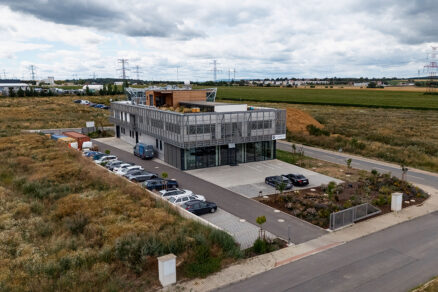 Vstup do administrativní budovy Narran s parkováním a prosklenou fasádou.