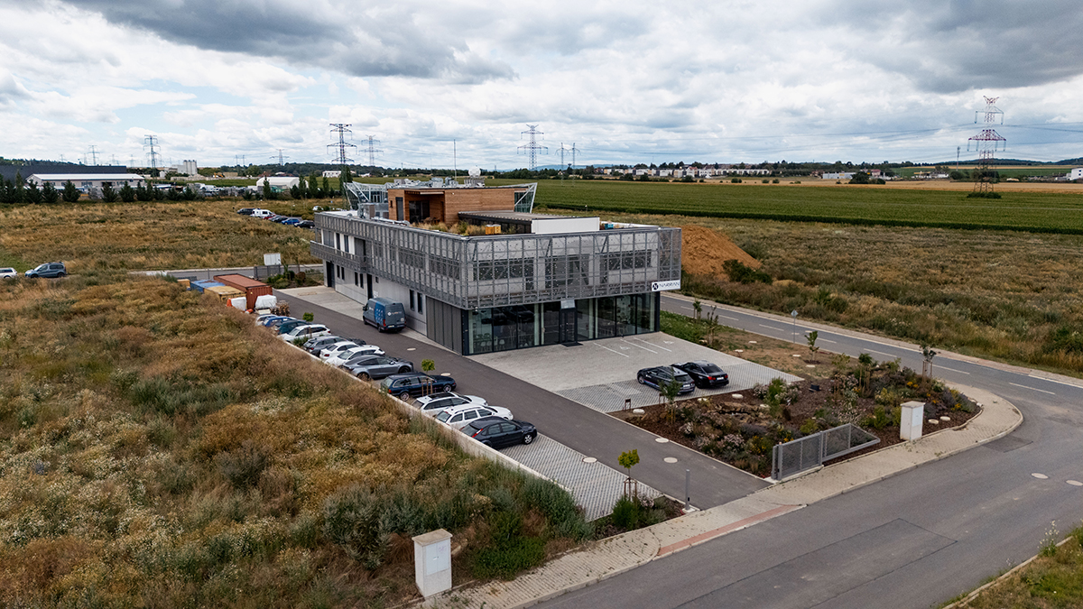Letecký pohled na administrativní budovu Narran ve Zlatníkách u Prahy v okolní krajině.