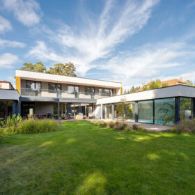 Moderní rodinný dům s velkoformátovým zasklením otevřený do zahrady u lesa