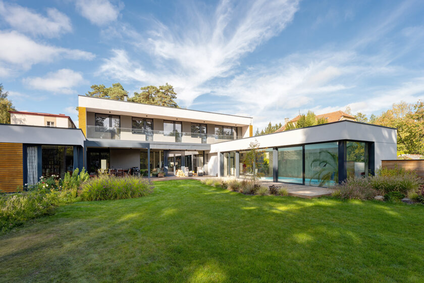 Moderní rodinný dům s velkoformátovým zasklením otevřený do zahrady u lesa