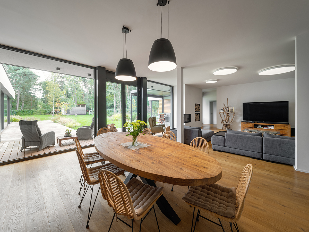 Otevřený obytný prostor s velkoformátovým zasklením a přímým vstupem na terasu