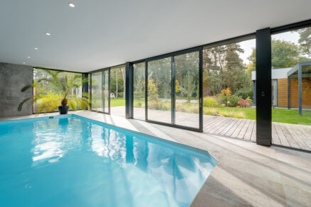 Interiérový bazén s velkoformátovými hliníkovými okny propojený se zahradou