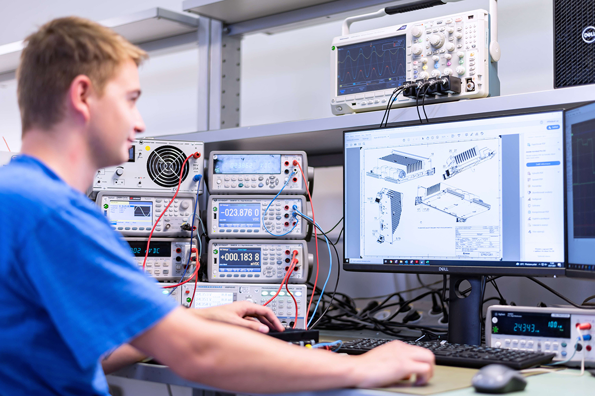 Inženýr testující elektronické moduly a řídicí systém v technické laboratoři