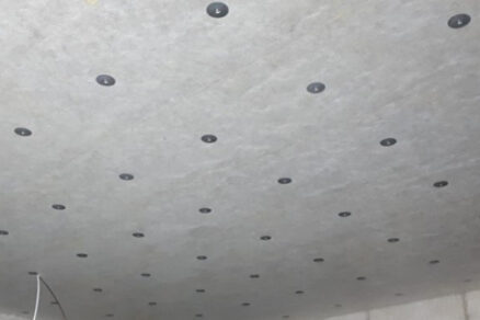 Strop suterénu s namontovanými izolačními deskami a viditelnými kotvami