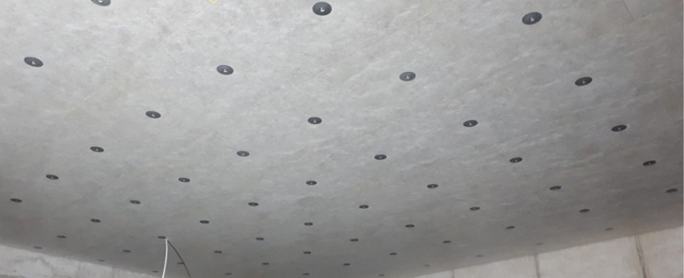 Strop suterénu s namontovanými izolačními deskami a viditelnými kotvami