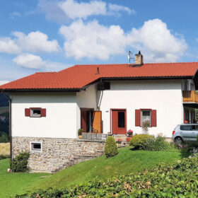 Rodinný dům s červenou střešní krytinou vhodnou pro rekonstrukci střechy