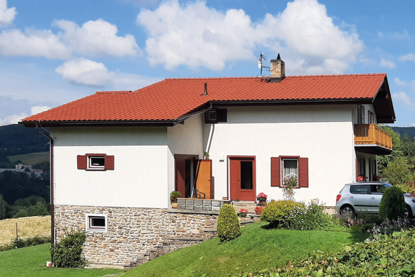 Rodinný dům s červenou střešní krytinou vhodnou pro rekonstrukci střechy