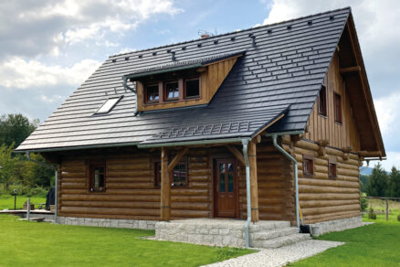 Dřevostavba s tmavou střešní krytinou a moderním střešním systémem
