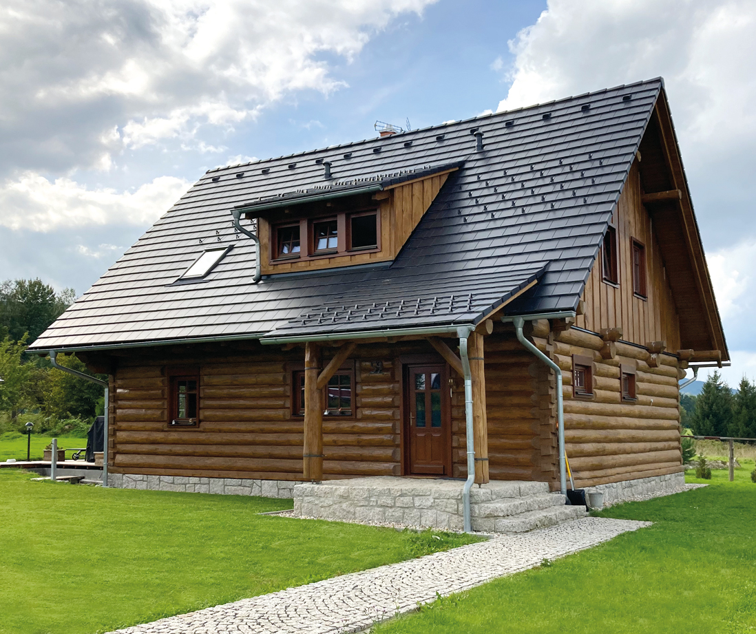 Dřevostavba s tmavou střešní krytinou a moderním střešním systémem