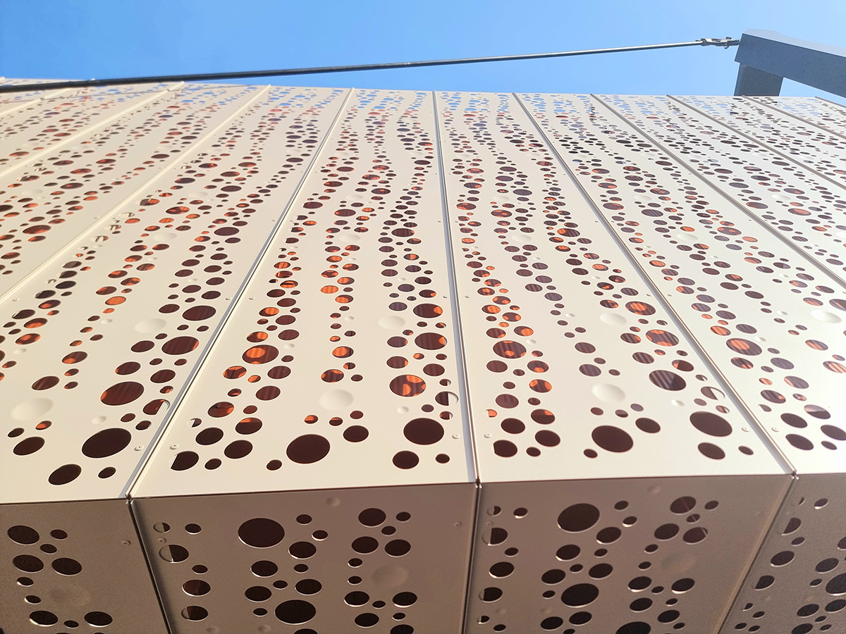 AVG perforovaná fasáda Perforovaná kovová fasáda moderní budovy s designovým řešením