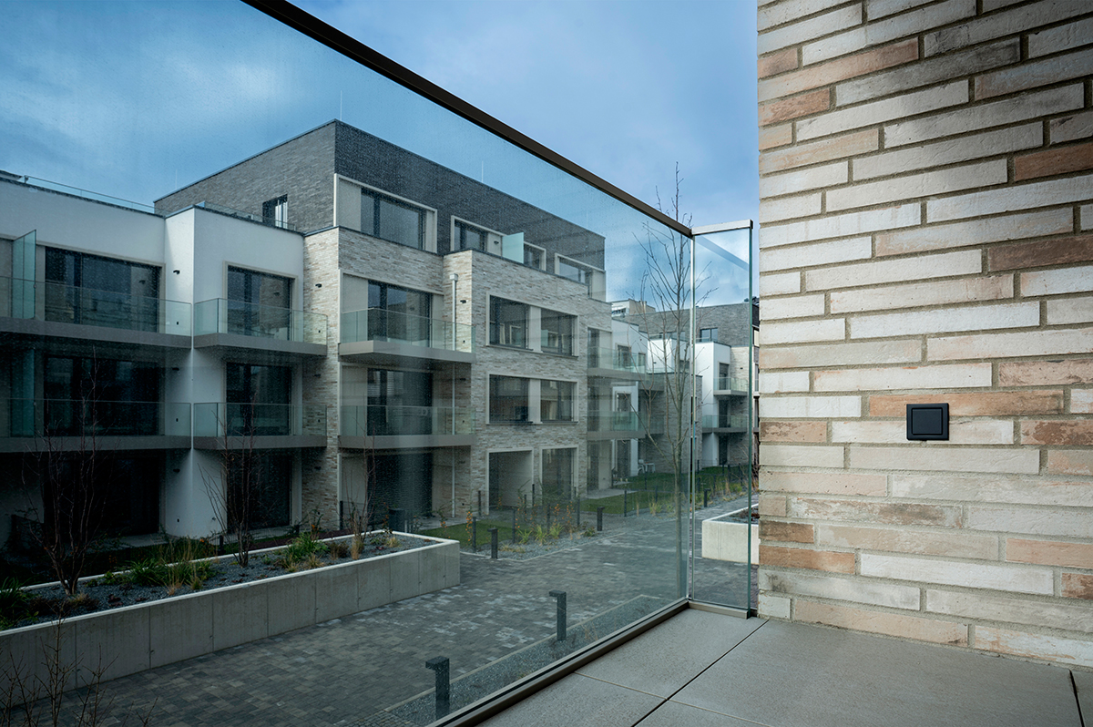 Balkon s výhledem na bytový komplex Astrid Garden a exteriérový vypínač