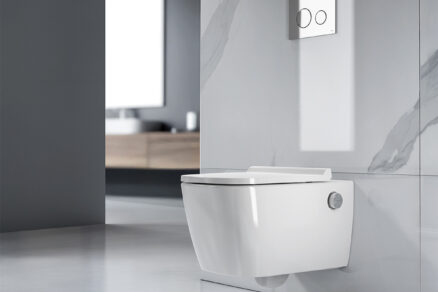 Sprchovací toaleta bez elektřiny instalovaná na stěně v moderní koupelně s podomítkovým splachováním.