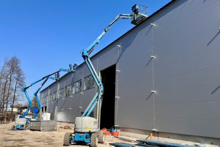 Dokončování opláštění průmyslové budovy pomocí výškové techniky