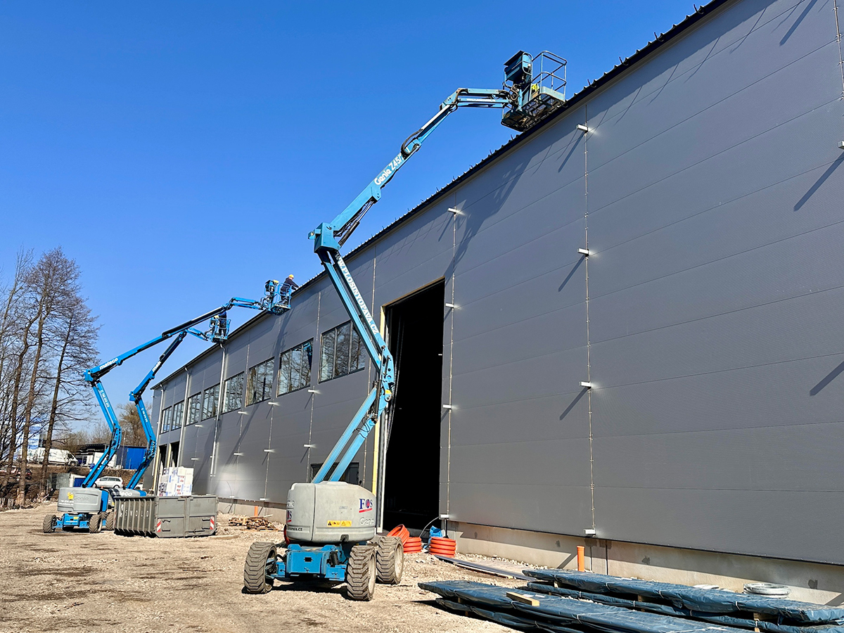 Dokončování opláštění průmyslové budovy pomocí výškové techniky