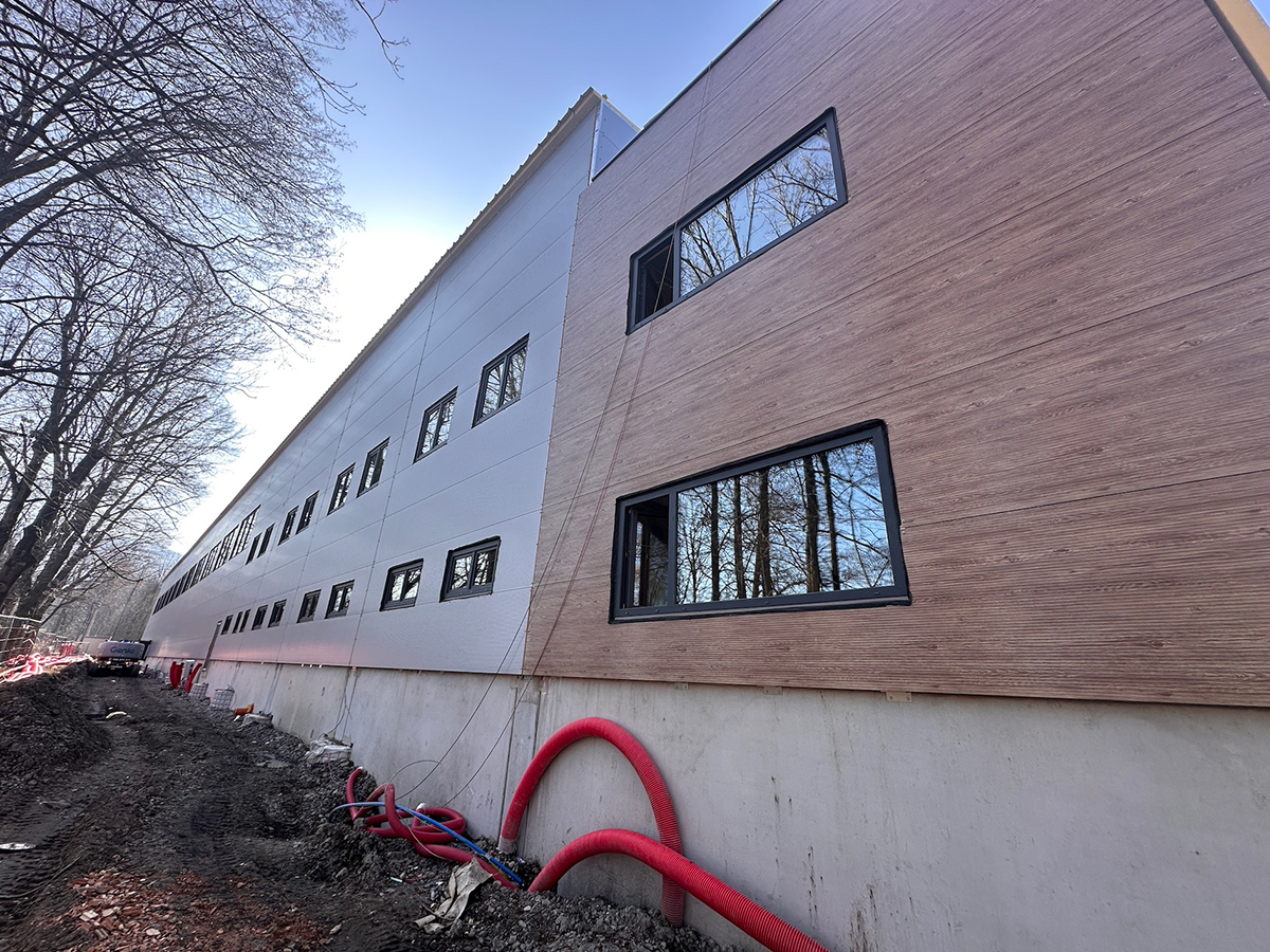 Detail moderní fasády průmyslového objektu s kombinací materiálů