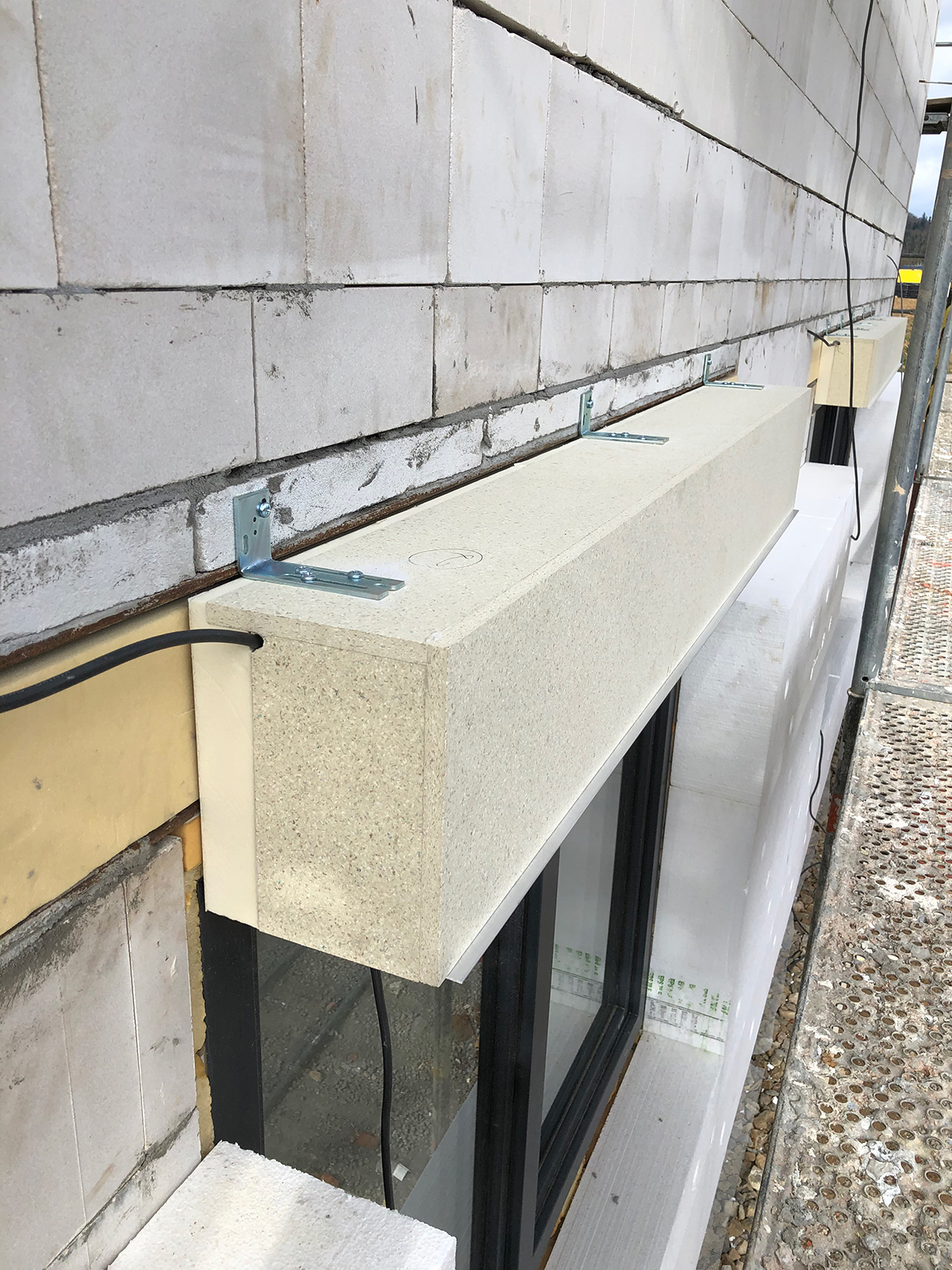 Detail uchycení kastlíku na žaluzie pomocí kovových úhelníků do zdiva