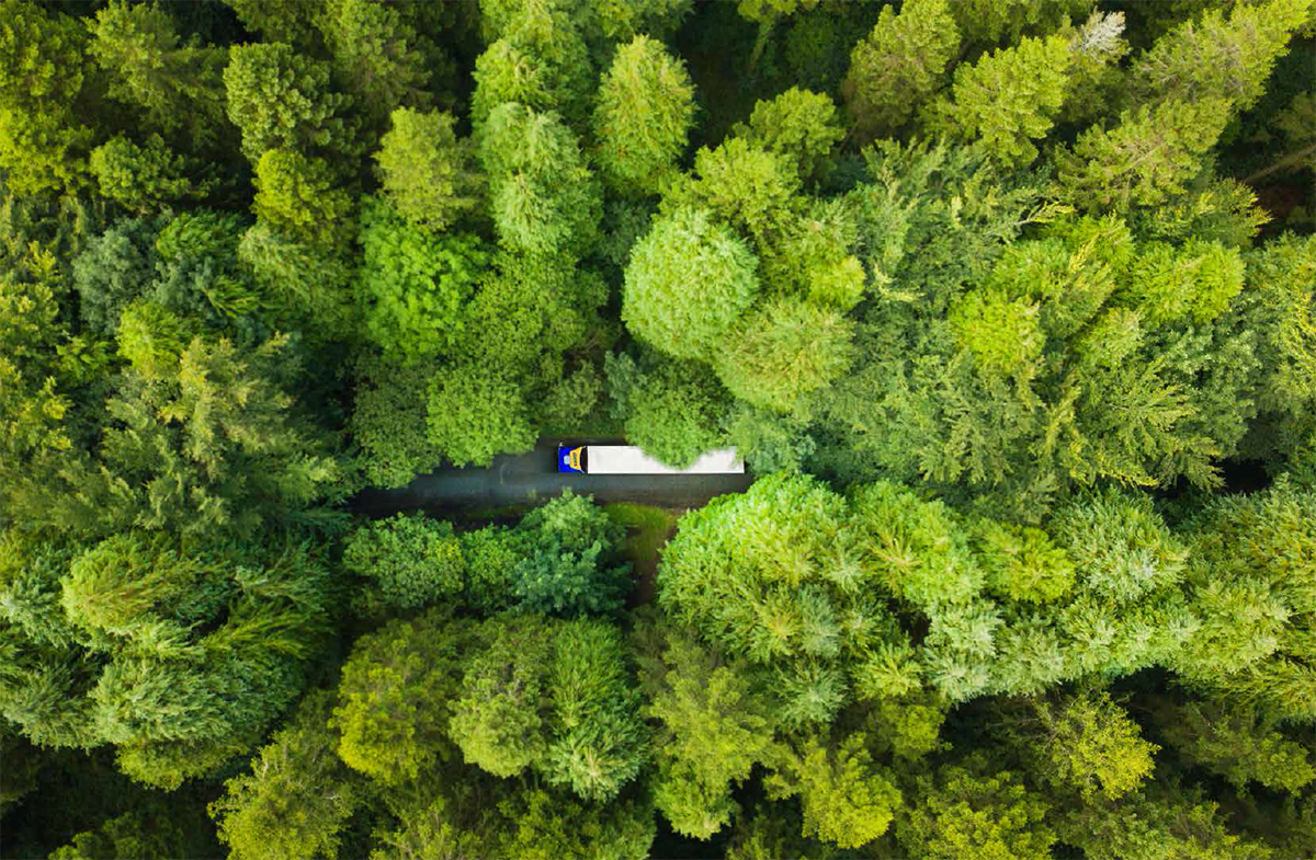 nákladné vozidlo prechádzajúce lesom z pohľadu zhora