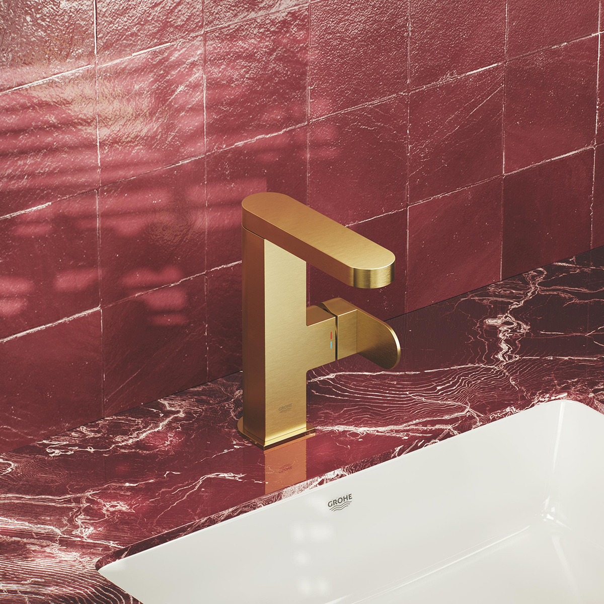 Koupelnová baterie v kontrastu s výrazným obkladem a deskou