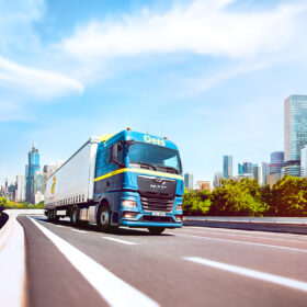 nákladné vozidlo prechádzajúce mestom s modernou infraštruktúrou