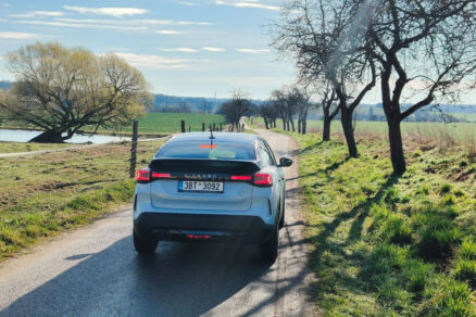 Citroën C4 jazdiaci po vidieckej ceste medzi stromami a lúkami