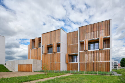 Fasáda s lodžiemi a dřevěnými okenicemi