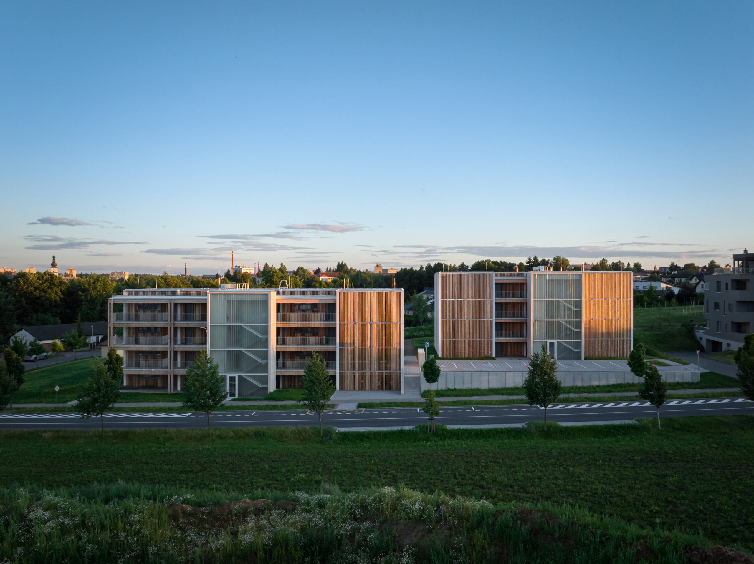 Celkový pohled na bytové domy v kontextu okolní zástavby a krajiny
