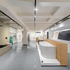Showroom koupelen s vystavenými vanami, vzorky materiálů a důrazem na čistý design a prezentaci produktů.
