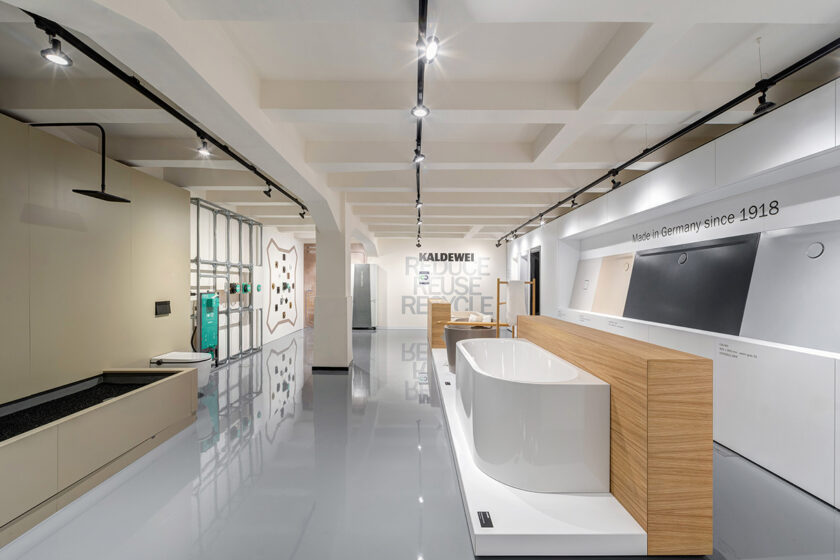 Showroom koupelen s vystavenými vanami, vzorky materiálů a důrazem na čistý design a prezentaci produktů.