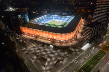 Večerní pohled na Národní fotbalový stadion v Bratislavě s nasvícenou fasádou a multifunkčním zázemím.