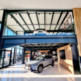 Showroom s ocelovou konstrukcí, velkými prosklenými plochami a vystavenými automobily