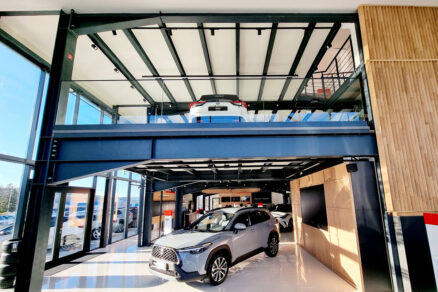 Showroom s ocelovou konstrukcí, velkými prosklenými plochami a vystavenými automobily