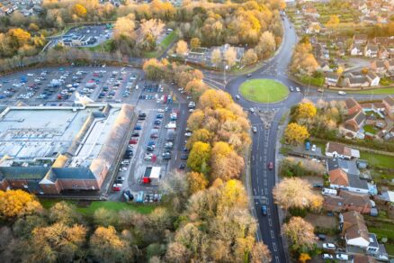 Letecký pohled na známý britský supermarket a velké parkoviště. Pohled na kruhový objezd v rušném Suffolku