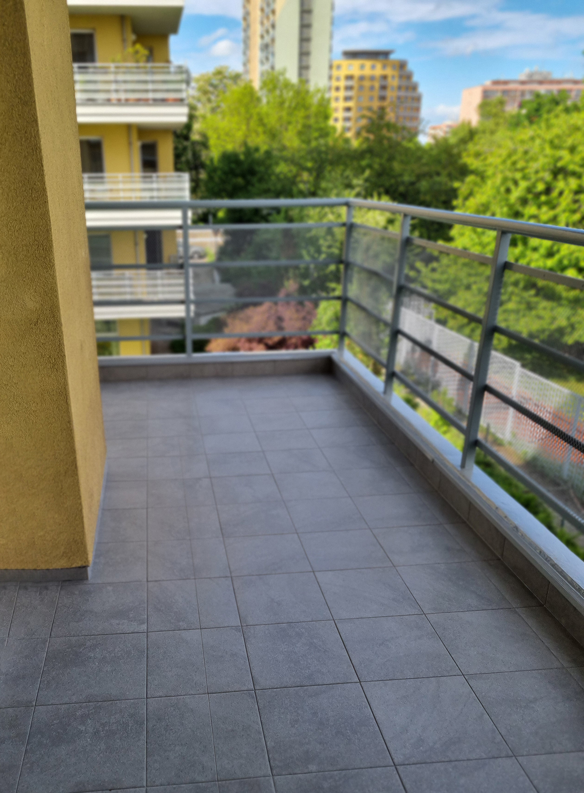 Zrekonstruovaný balkon s keramickou dlažbou, odvodňovacím vpustem a novou hydroizolační skladbou.